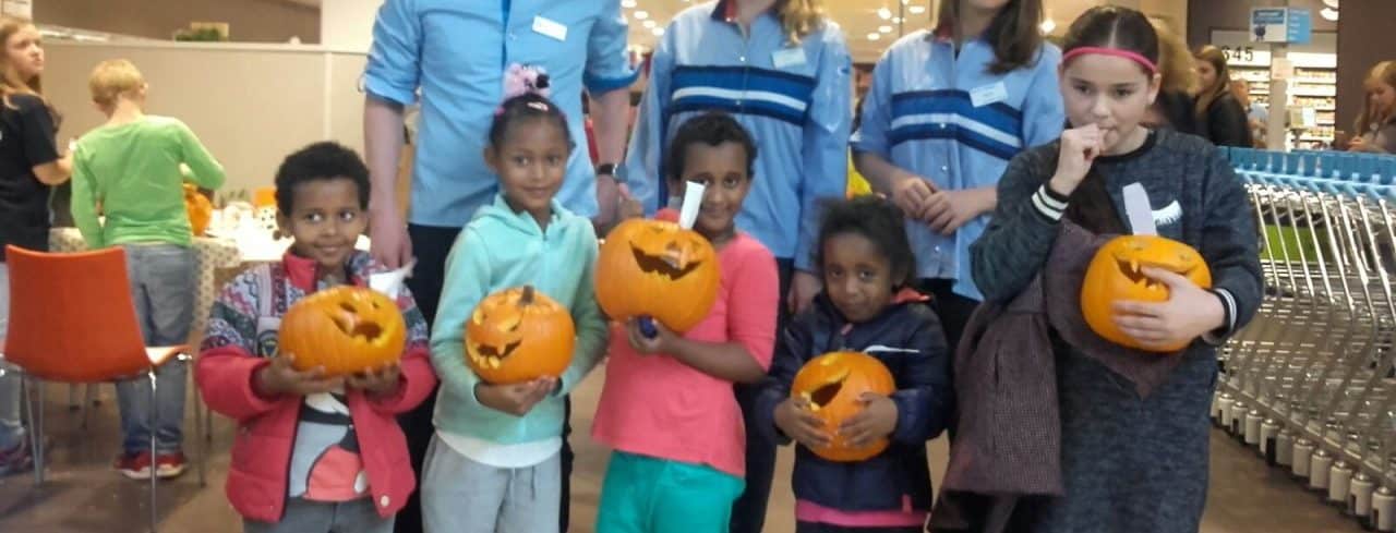 Huiskamerkinderen hollen pompoenen uit bij de Albert Heijn